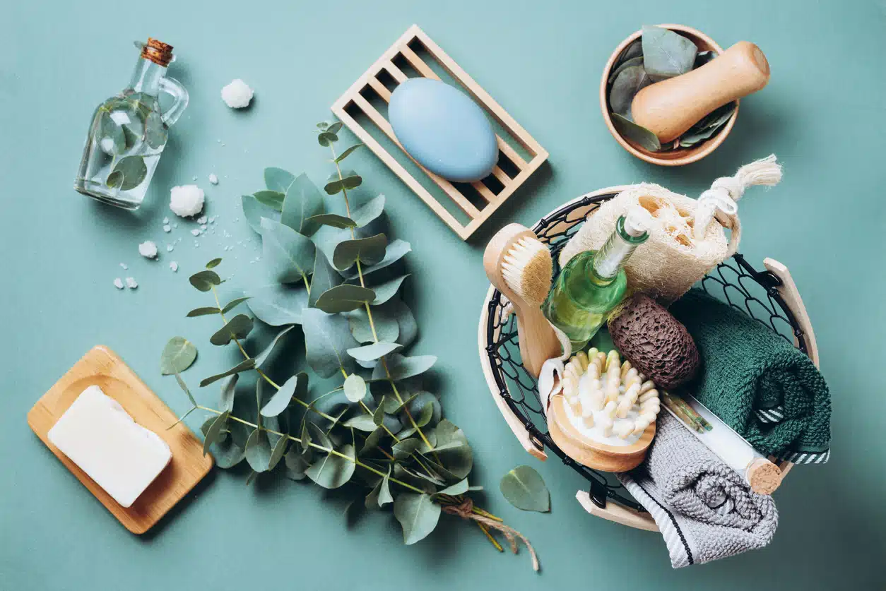 Wooden soap dish, soap, eucalyptus over green background. Zero waste, natural organic bathroom tools. Plastic free life. Ecological skin care, body treatment concept.