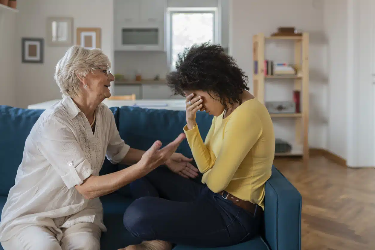 Older Mother Comforting Sad Adult Adopted Mixed Race Grown Daughter