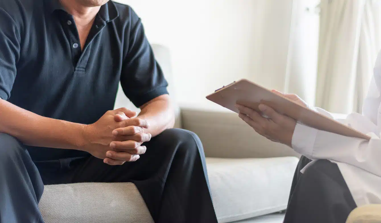 Doctor physician consulting with male patients in hospital exam room. Men's health concept