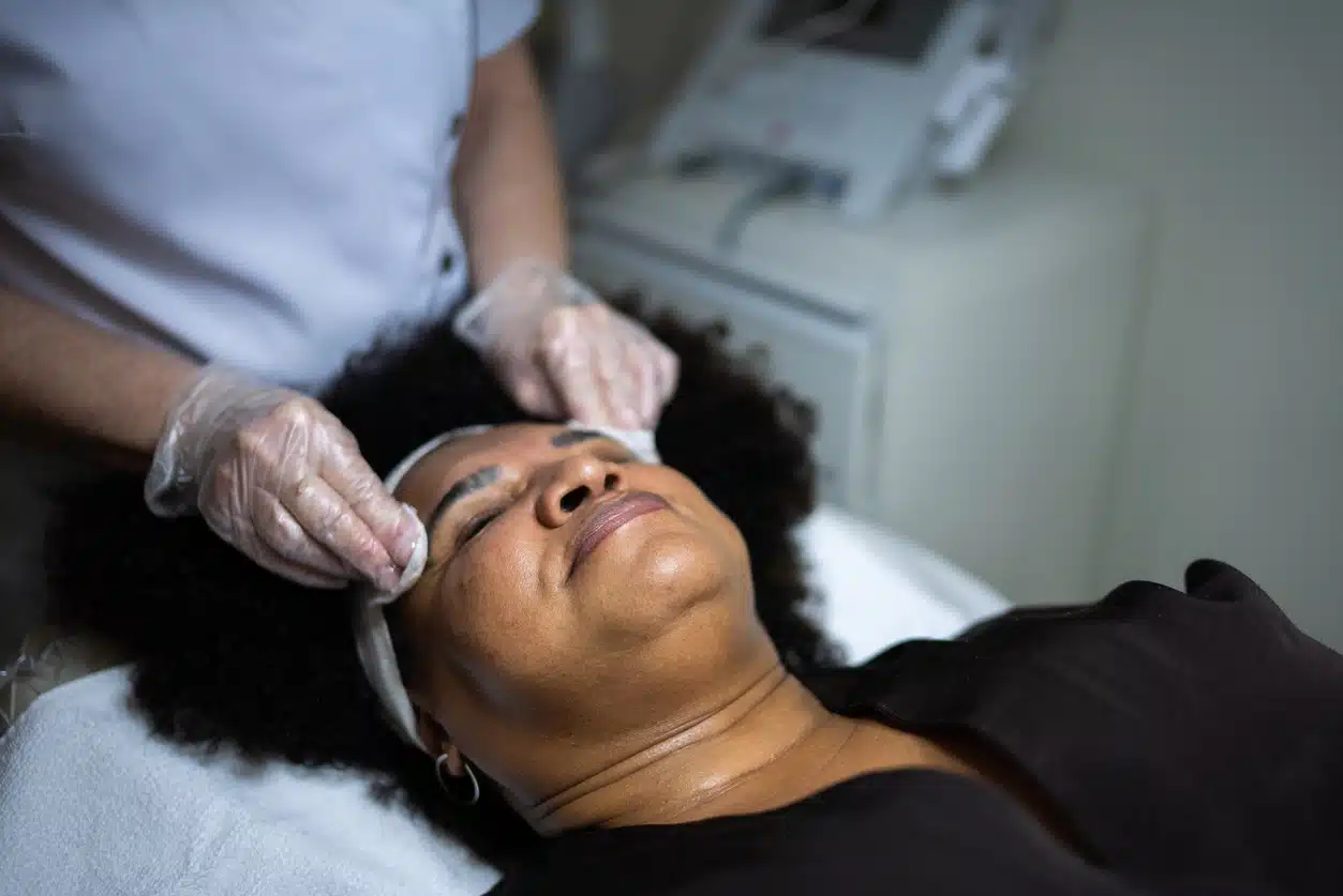 Beautician cleaning customer's skin in a spa