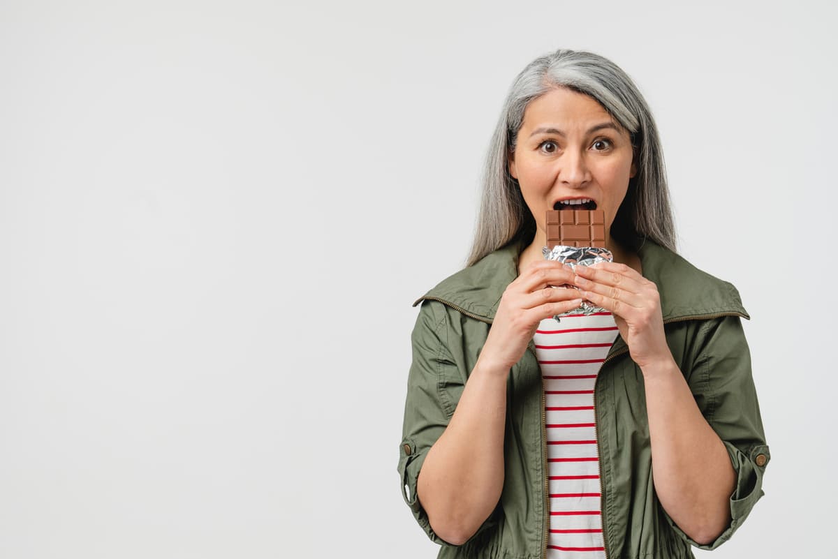 is sugar addictive? Woman eating a candy bar