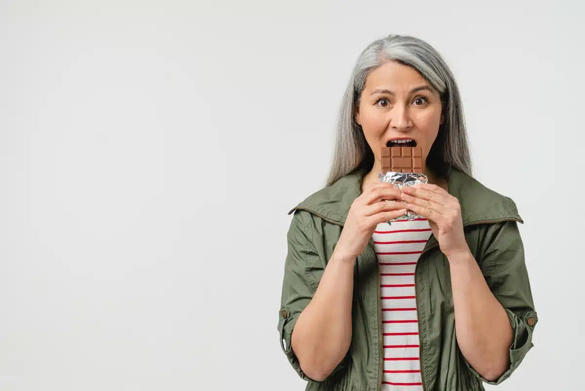 is sugar addictive? Woman eating a candy bar
