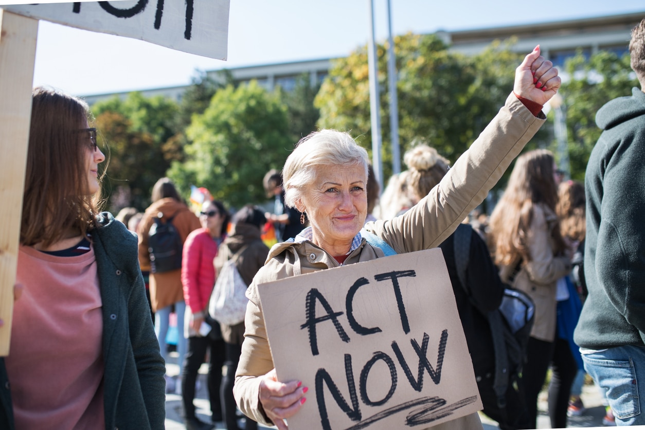 Woman with Act Now Placard