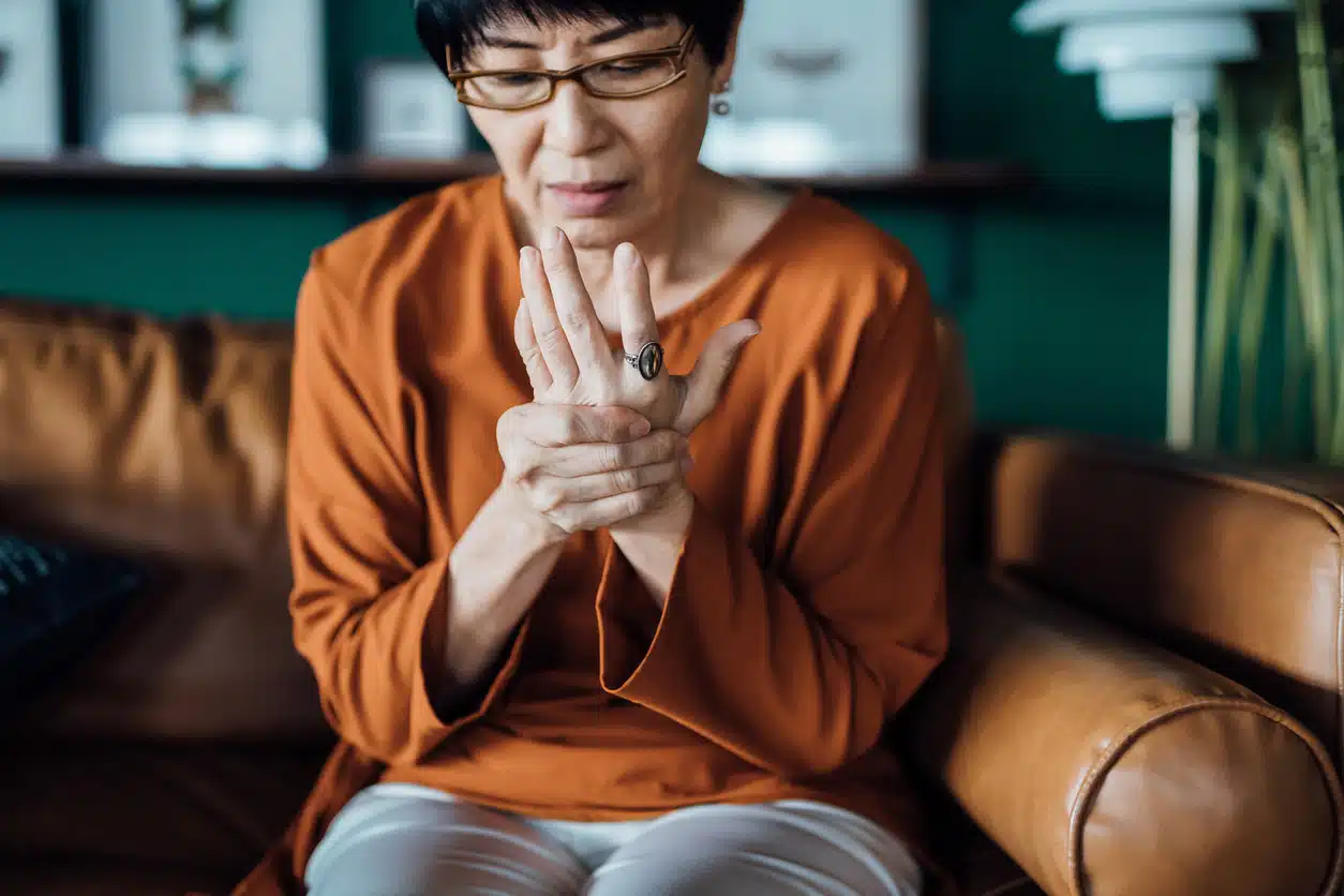 Woman rubbing her aging hands