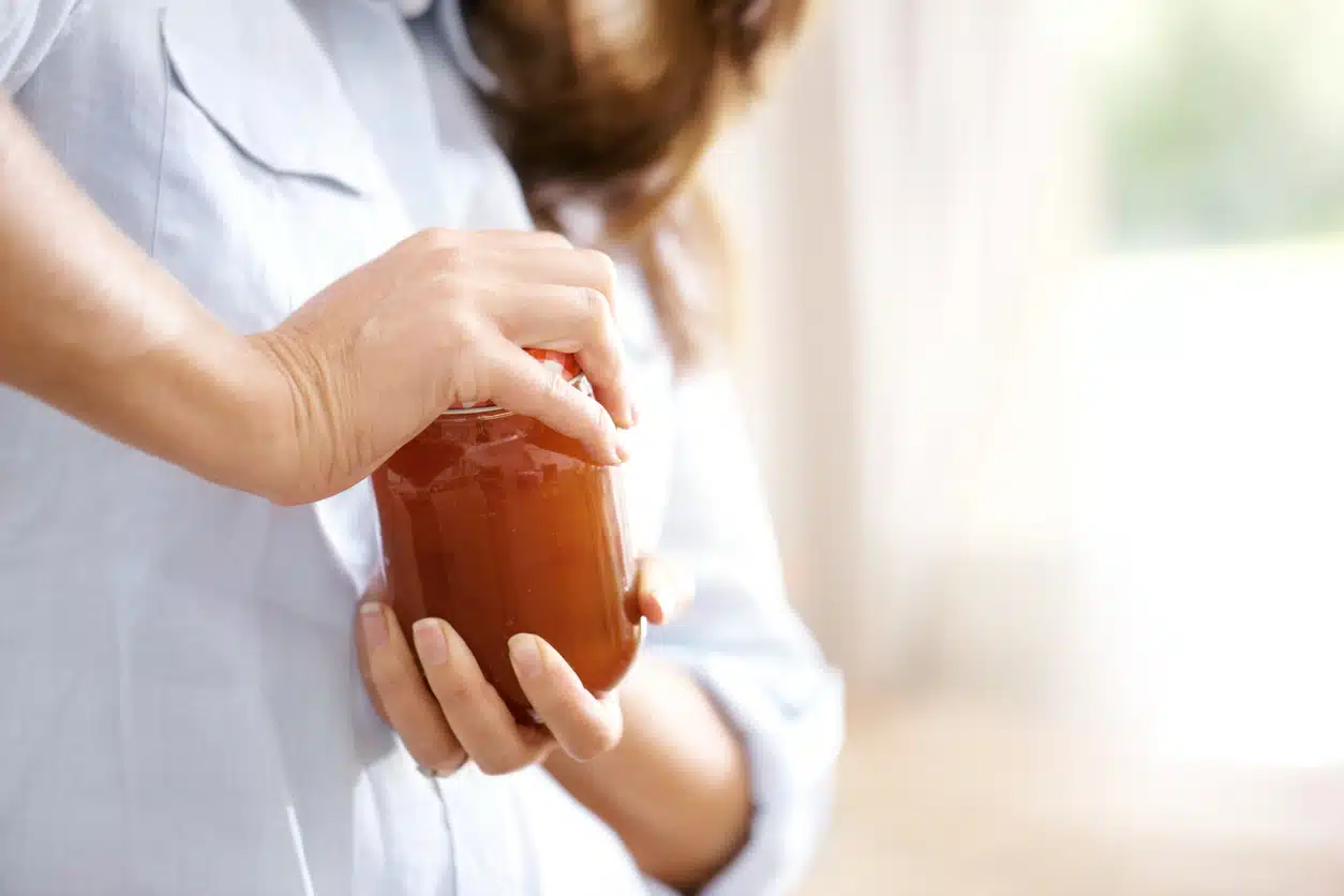 Woman trying to open a jar