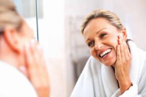 Best skincare buys, woman looking in the mirror