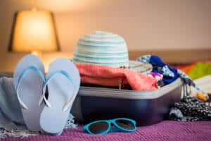 Open suitcase, pack for a warm weather vacation