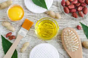 DIY Beauty - Small glass bowl with peanut (groundnut) oil and raw egg yolk. Natural face and hair mask recipe. Ingredients of homemade cosmetics. Top view, copy space.