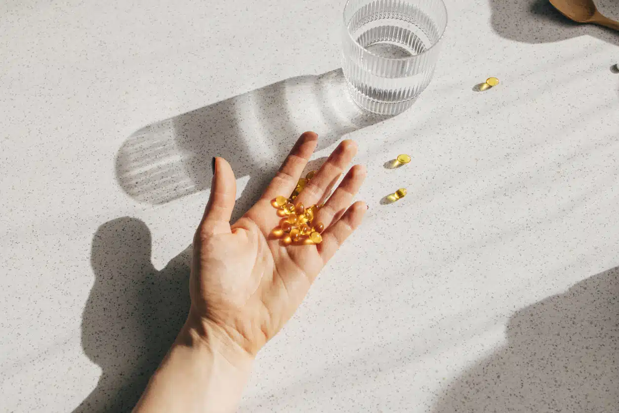 A high angle shot of an unrecognizable person's hand holding a bunch of vitamin D pills.