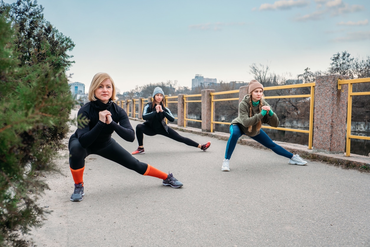 Outdoor gym fitness classes, outside workout. Fitness in the fresh air. Safer outside. Group fitness classes, HIIT training, Run Clubs, Strength Circuits. Three women are training in city park.