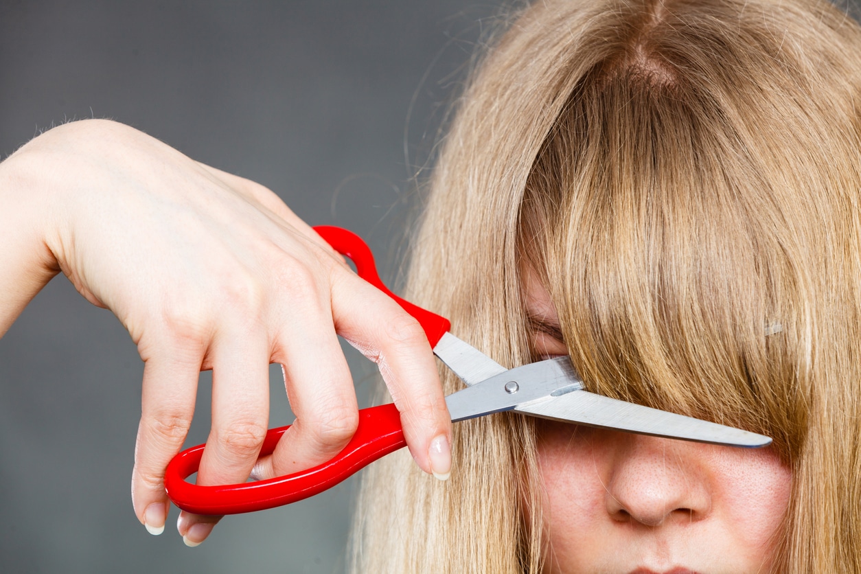 Woman cutting her fringe.