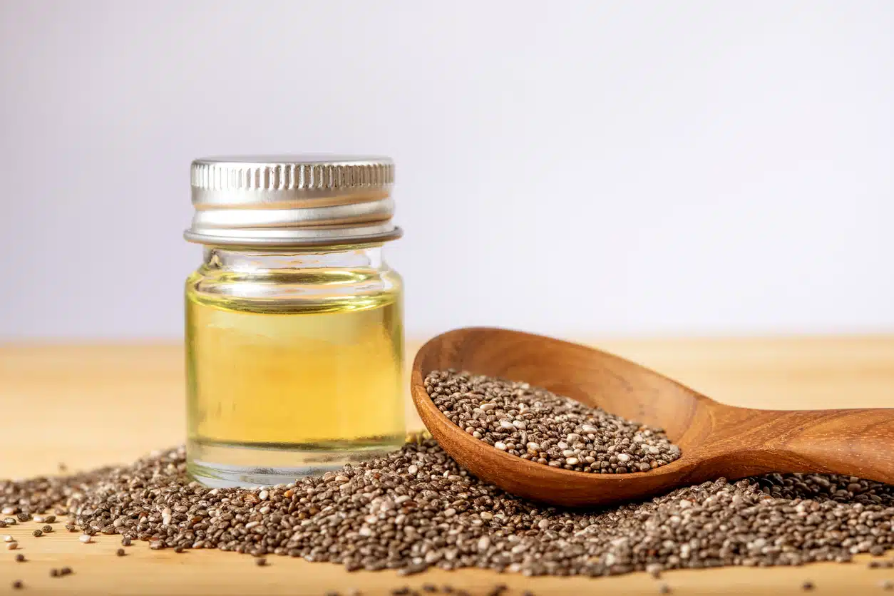 Close up a Chia essential oil and seeds in wooden spoon , superfood and rich of nutrient an antioxidant