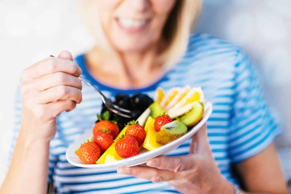Woman eating a fruit plate
