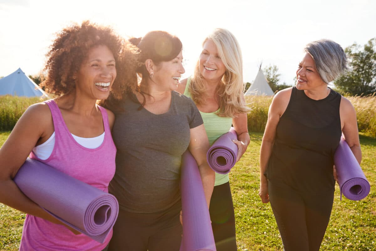 Group Of Mature Female Friends On Outdoor Yoga Retreat