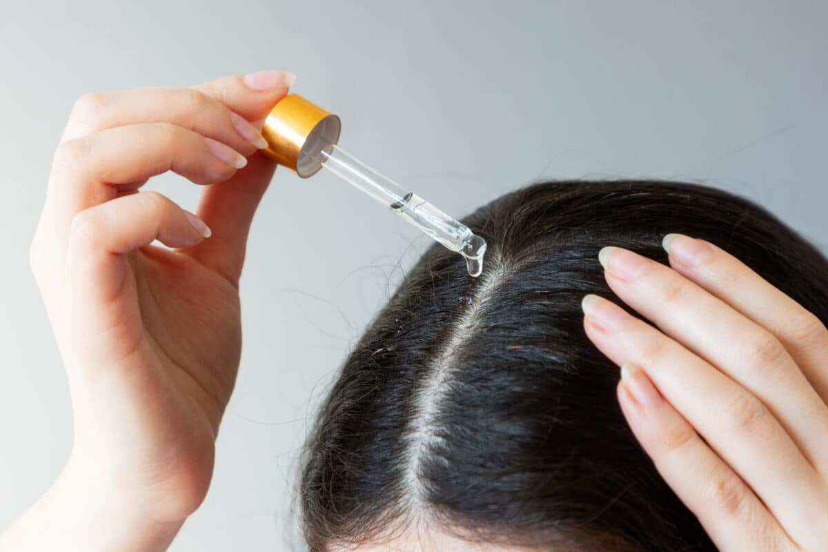 Woman putting oil in her hair