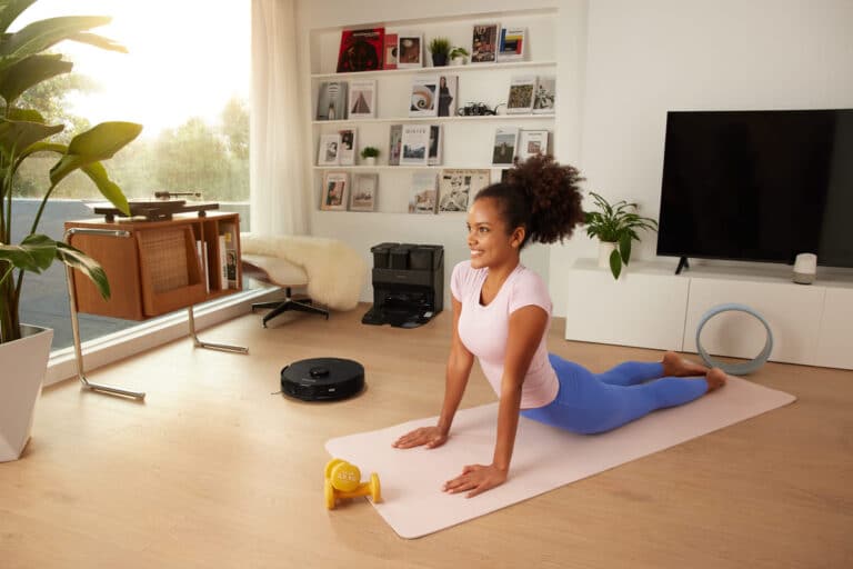 Woman doing yoga while Roborock works