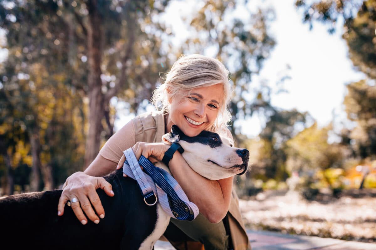 Woman hugging her dog on a walk