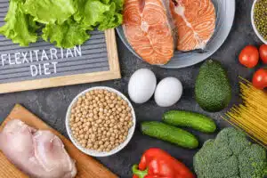 A set of products for a flexible diet. Salmon steak, chicken, chickpeas, mung beans and vegetables on a black background.