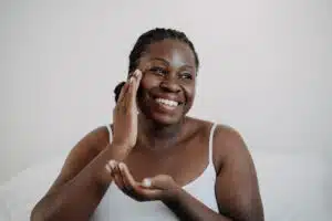 Woman putting cream on her face