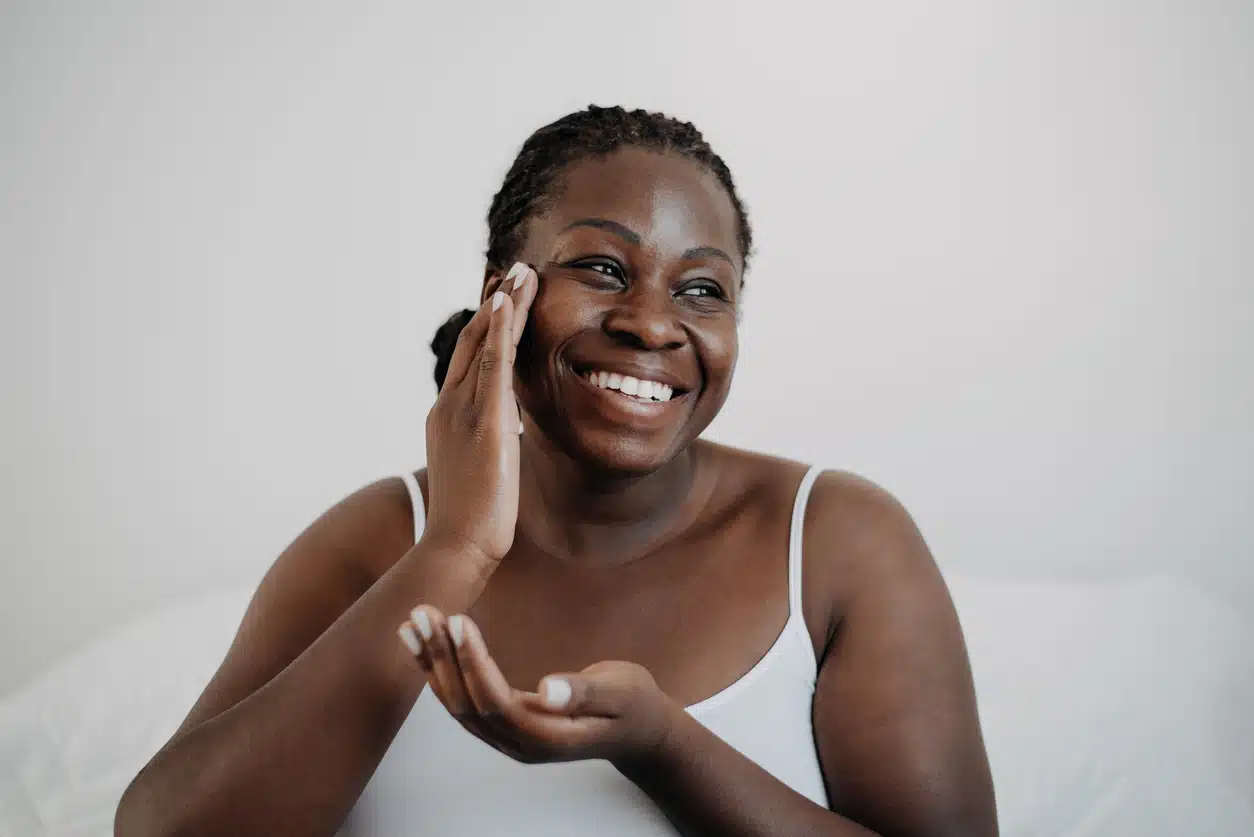Woman putting cream on her face