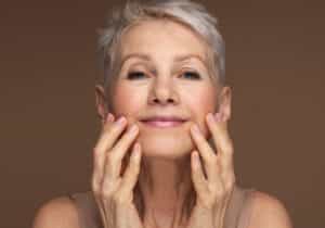 Thermo-fractional facials, woman with gray hair looking at her face