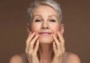 Thermo-fractional facials, woman with gray hair looking at her face
