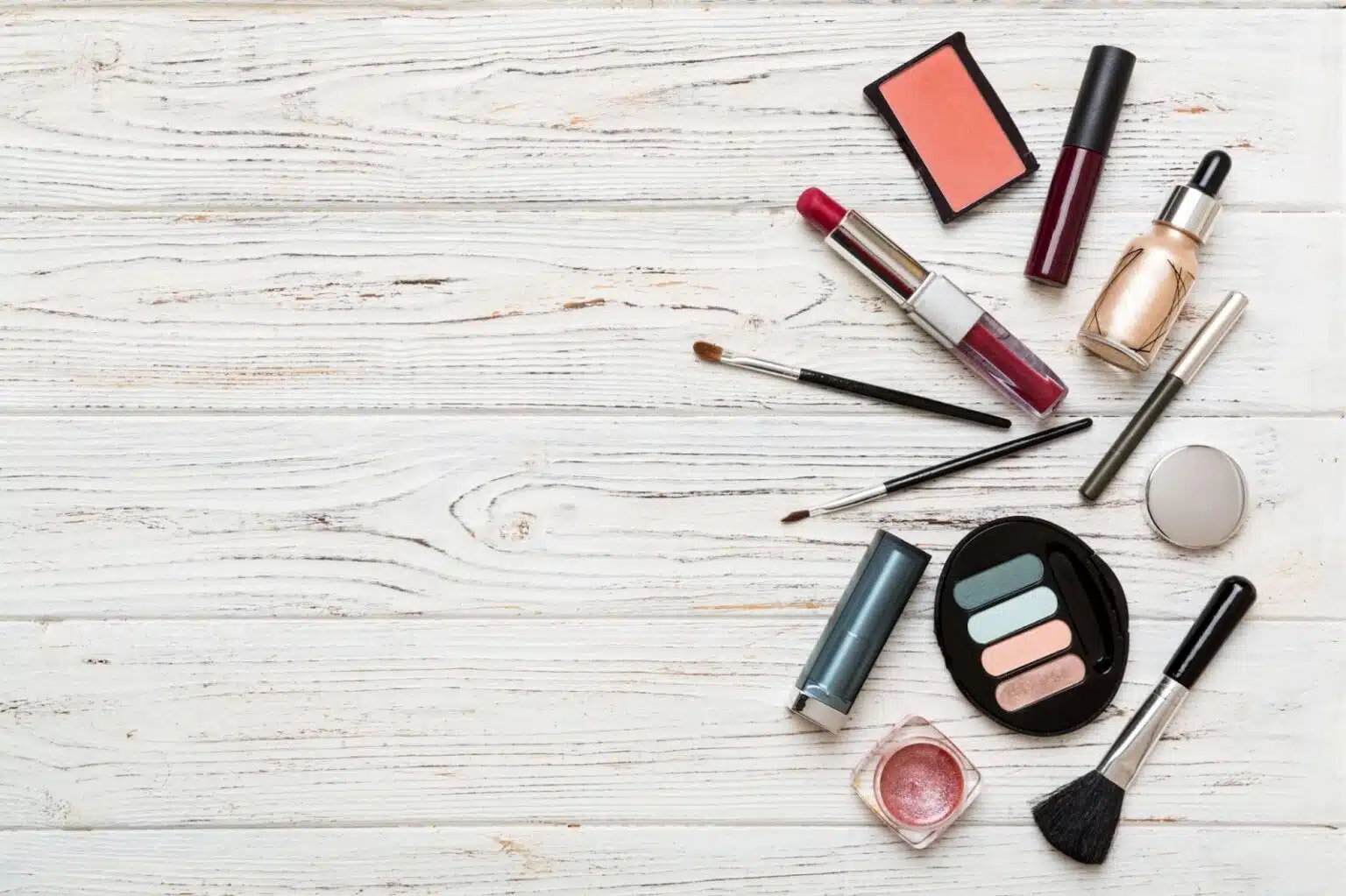 Cosmetic makeup and brushes on a tan background; makeup and raw materials concept. Open space for title