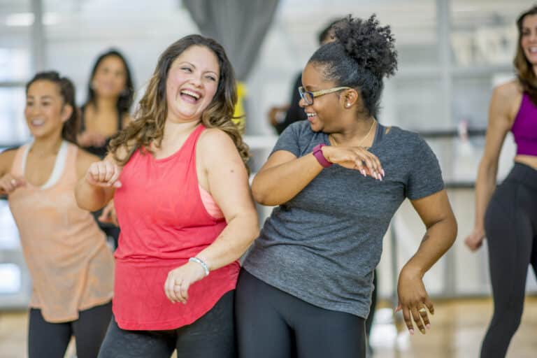 Women dancing to workout; sculpt society