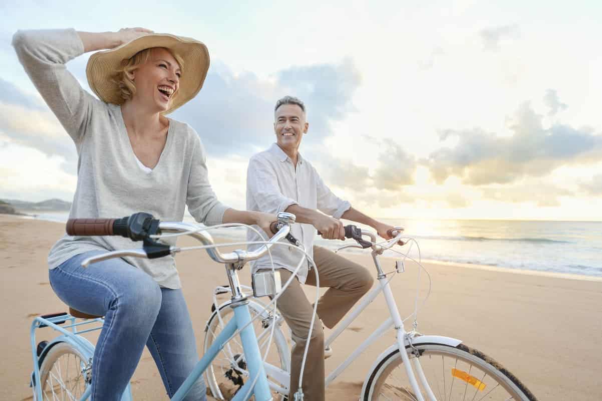 couple riding bikes at the beach