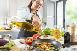 Woman cooking with olive oil; olive oil and dementia prevention