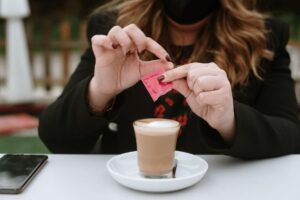 woman putting artificial sweetener in her coffee