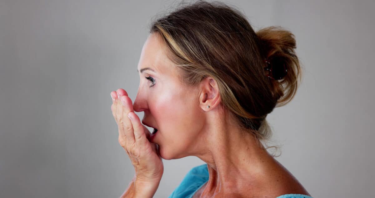 woman checking her breath; bad breath; halitosis.