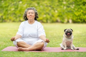 woman meditating with a dog