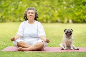 woman meditating with a dog