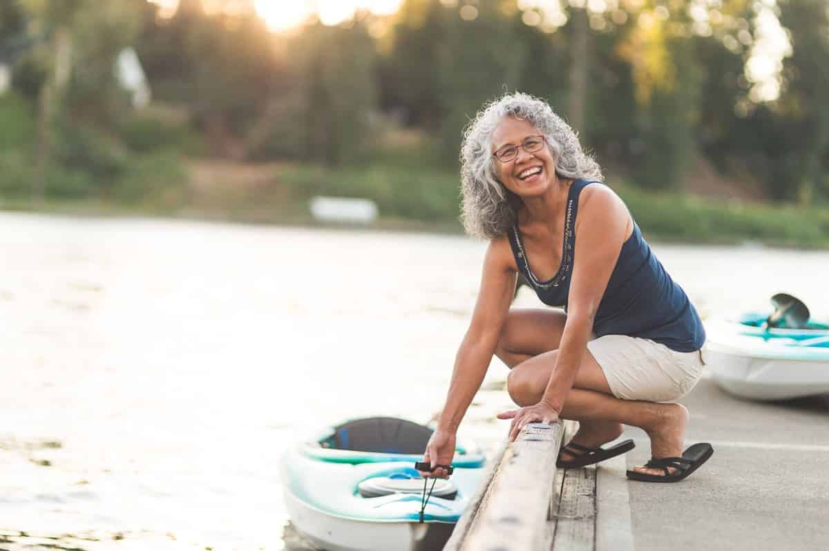 Active and health grey haired woman with a kayak