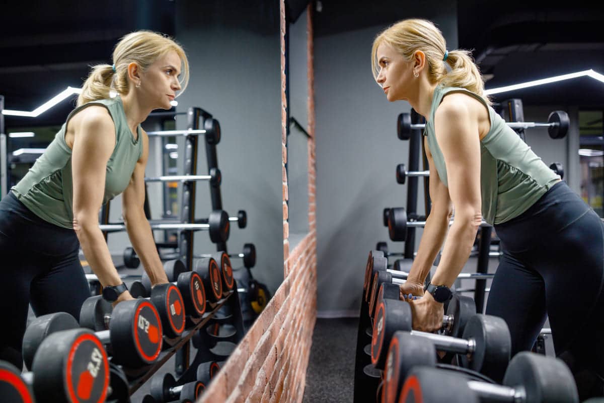 exercise and skin, woman working out and looking in the mirror, weight lifting