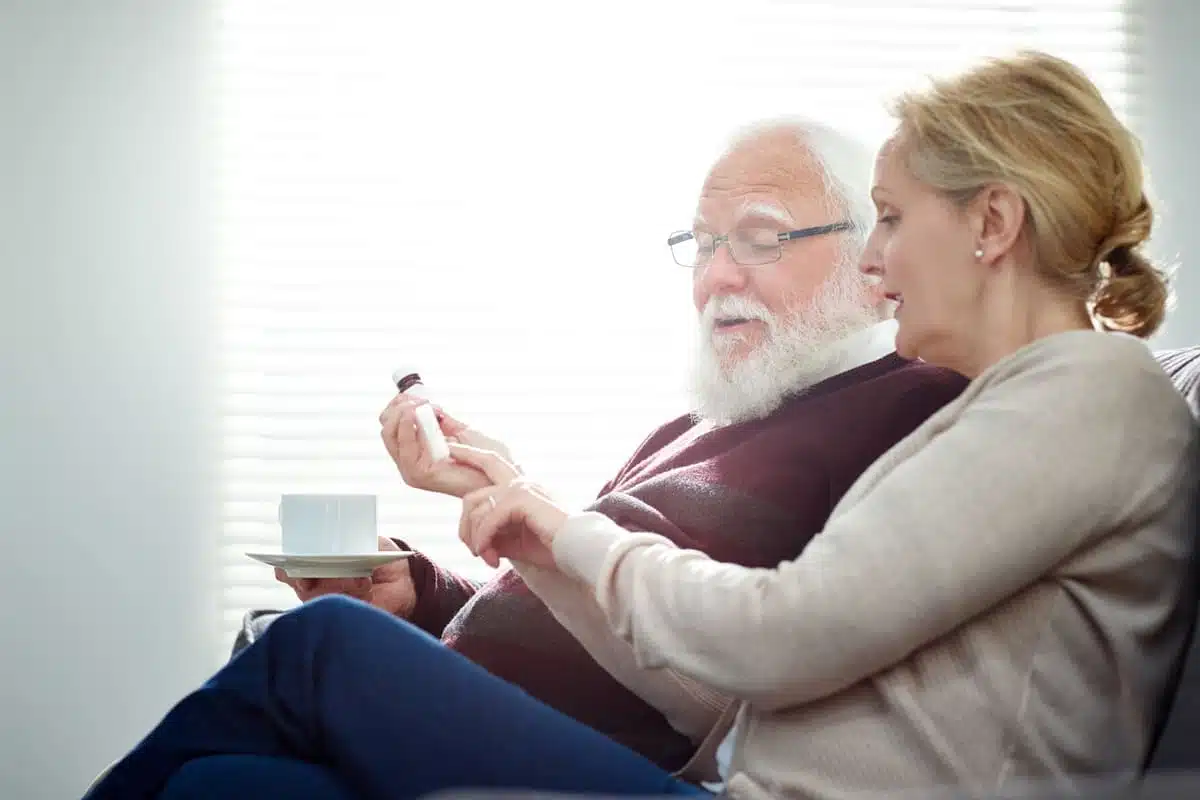woman going over medications with elderly father