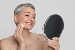 Flexible skincare routine for women over 50; great skin; looking in mirror