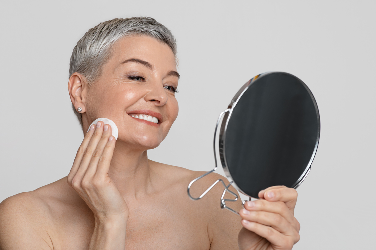 Flexible skincare routine for women over 50; great skin; looking in mirror