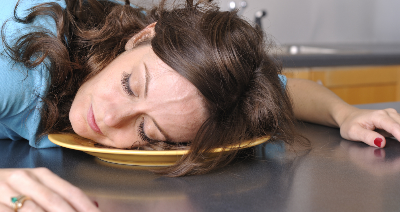 Tired woman at table after meal; Turkey and tryptophan feature