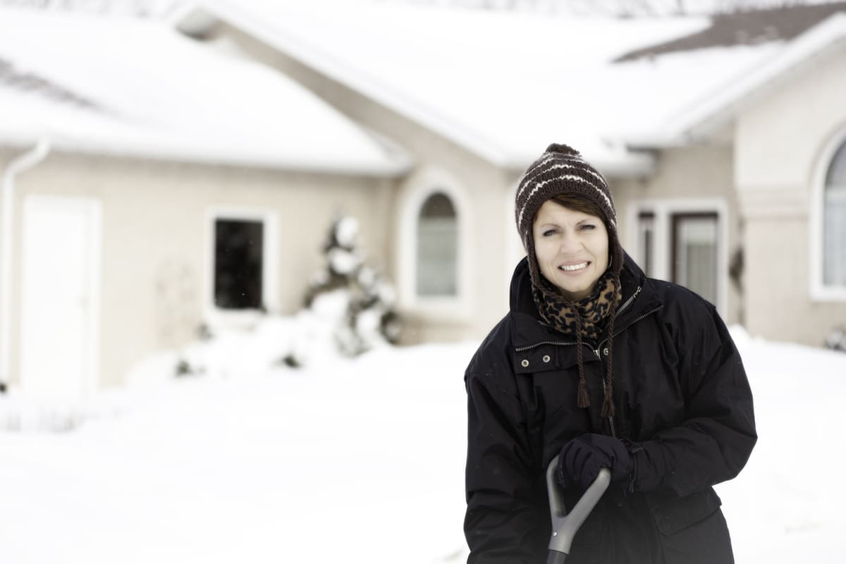 woman snow shoveling
