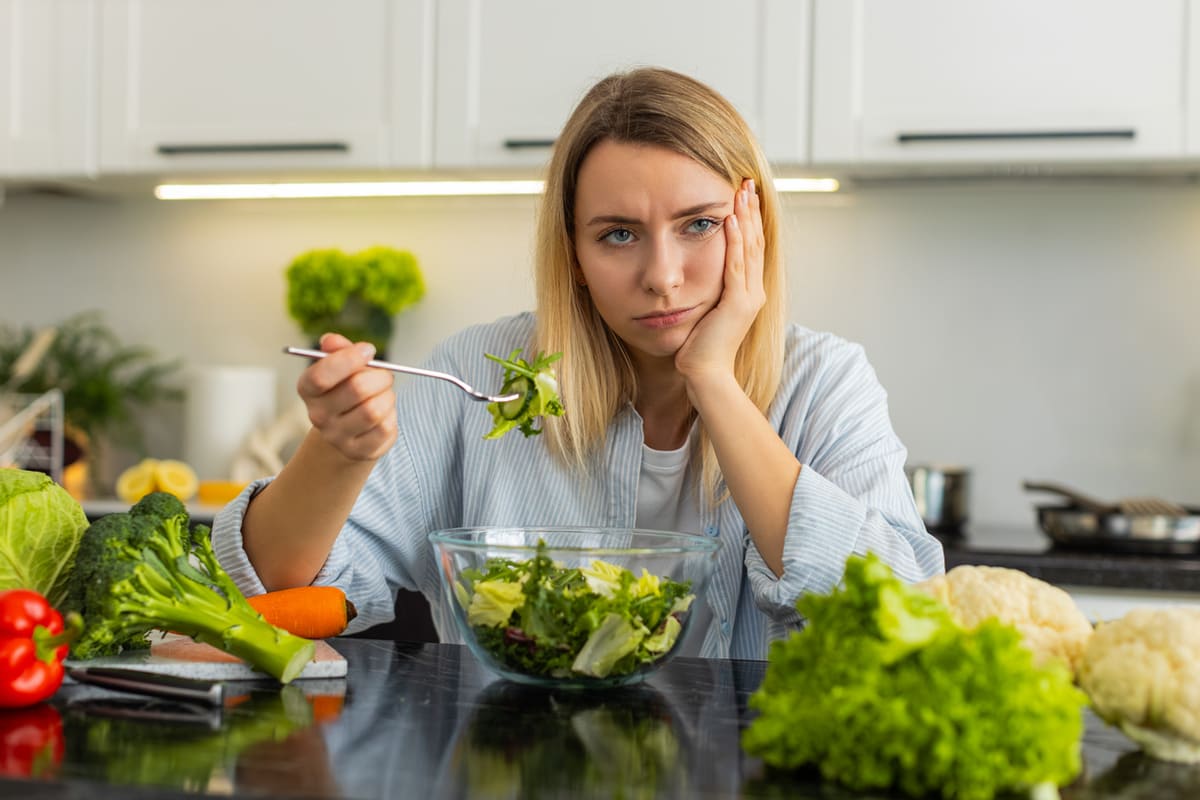 Woman eating a salad and sad about it; How to get fit when you hate diet and exercise