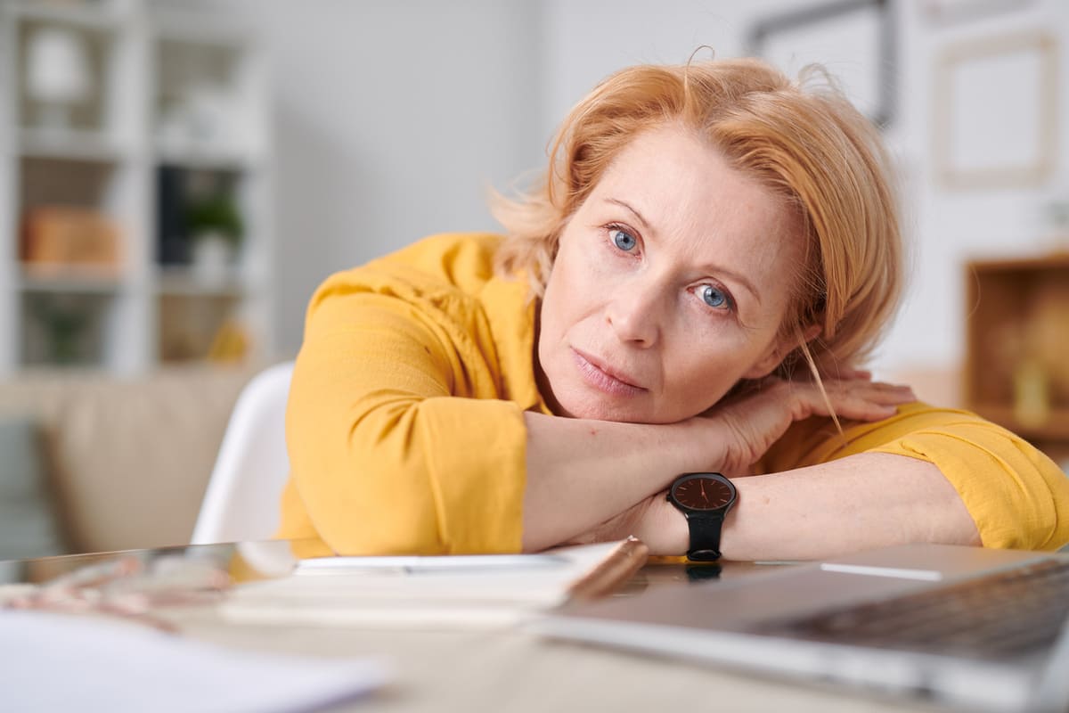 tired woman resting her head on her desk