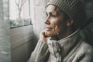 woman looking out the window at winter weather