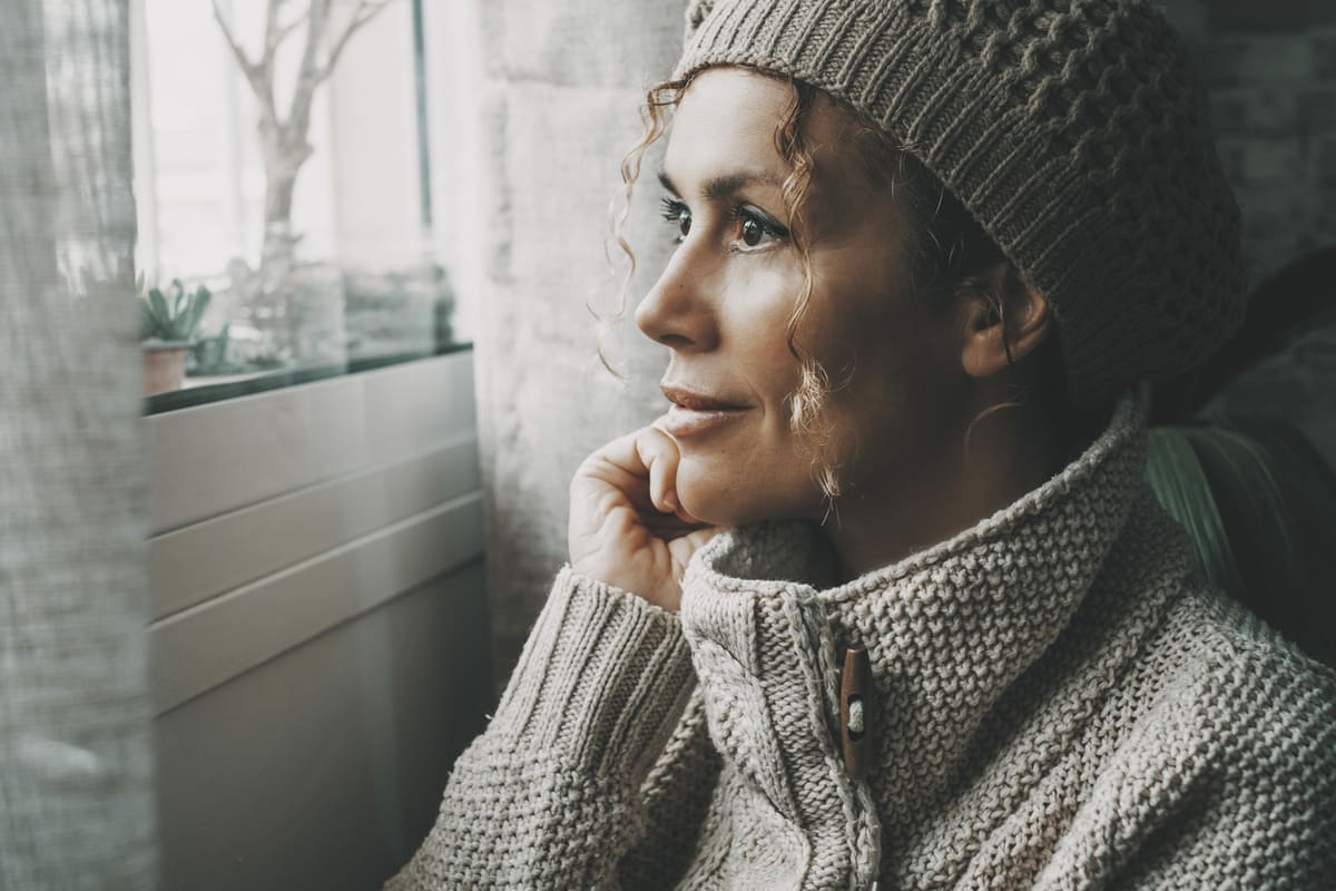 woman looking out the window at winter weather