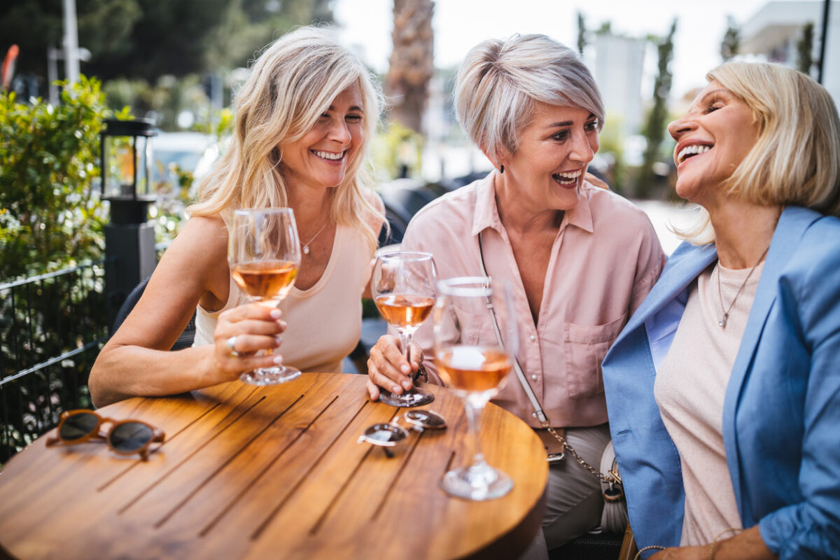 Women drinking wine and enjoying friendship at an outdoor patio