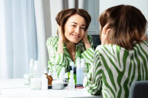 psycho-dermatology, woman looking in mirror, psychology and skincare