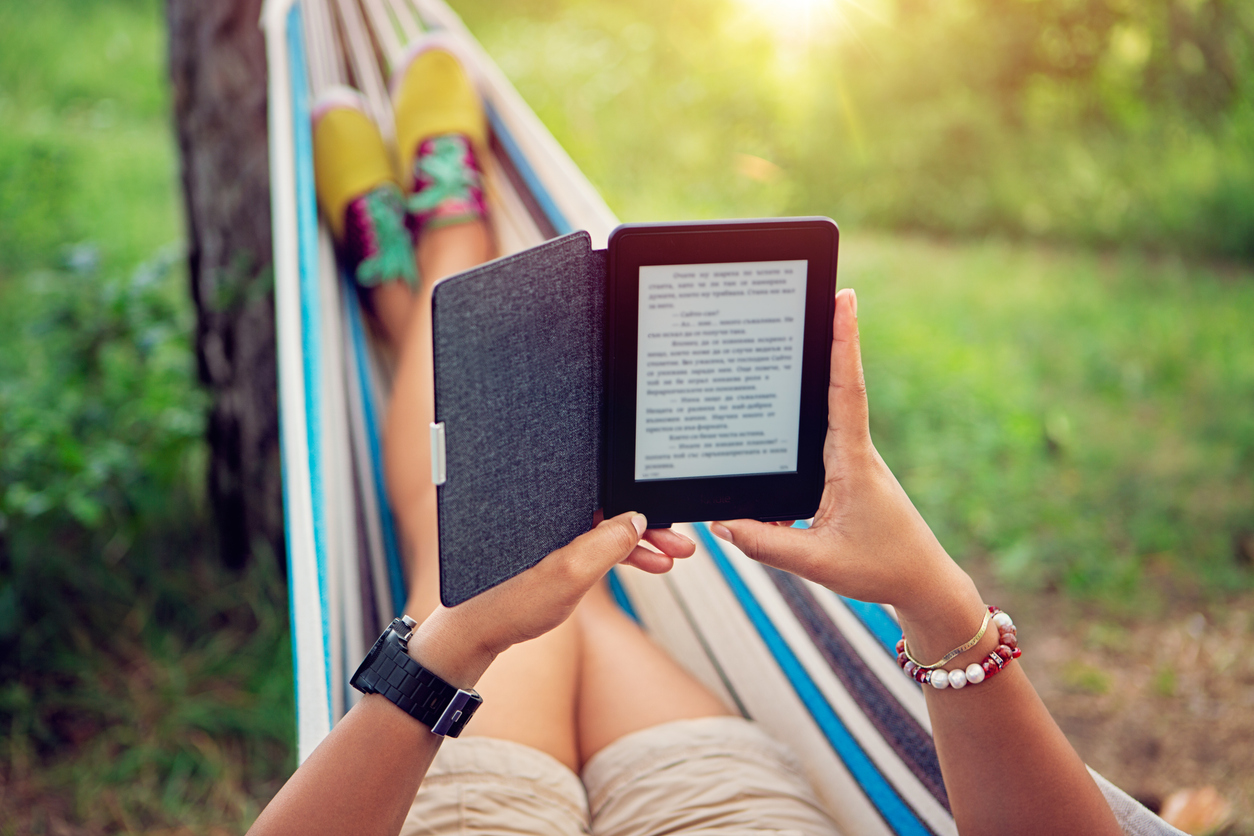woman reading an ebook in a hammock, summer reading list