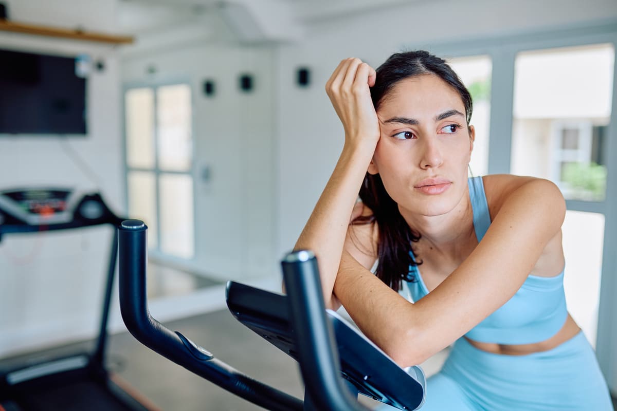 gym mistakes feature; frustrated woman working out