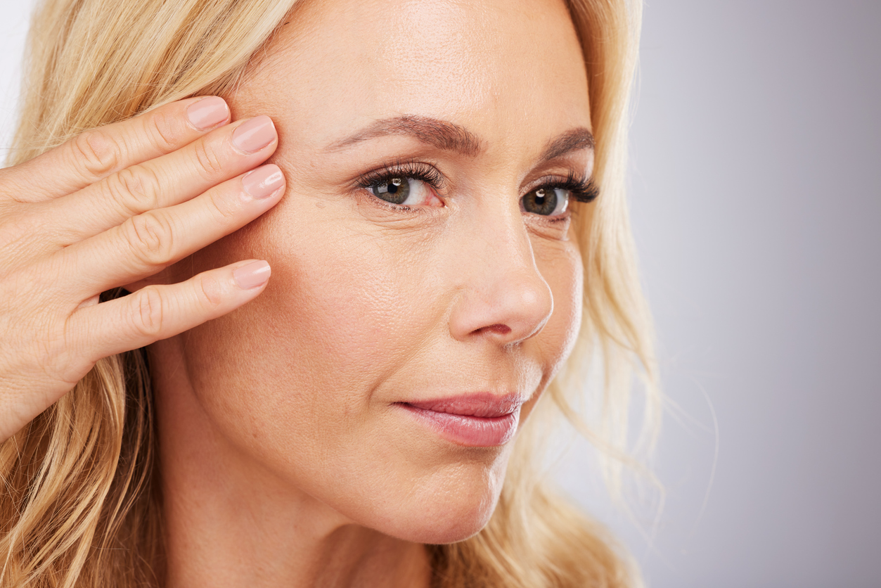 Face, skincare and antiaging; woman looking at her face